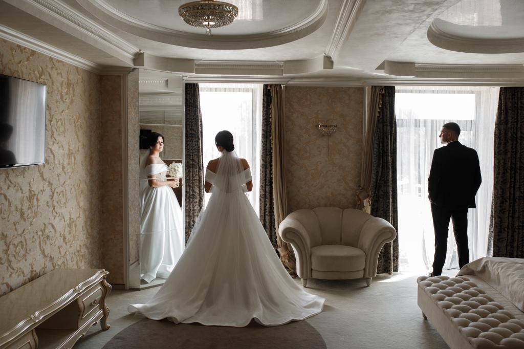 A bride and groom looking at each other for the first time in a room