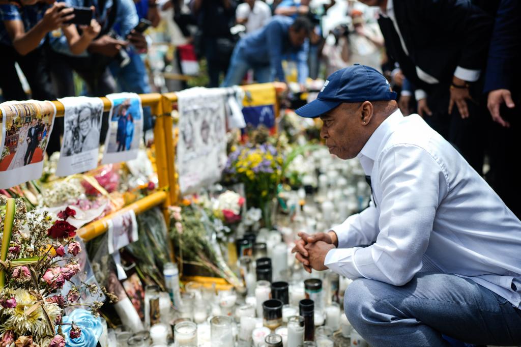 Adams squats at the memorial honoring those who died in the tragic collapse.