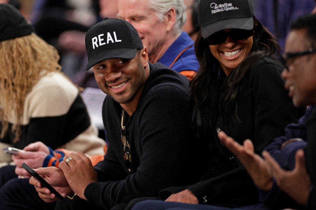Giants quarterback Russell Wilson, left, with his wife Ciara, looks towards Chris Rock during the second half of an NBA basketball game between the LA Clippers and the New York Knicks Wednesday, March 26, 2025.