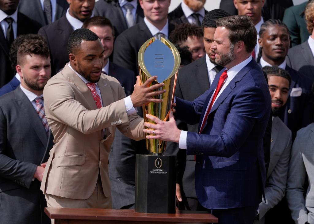 TreVeyon Henderson and JD Vance corral the CFP trophy.