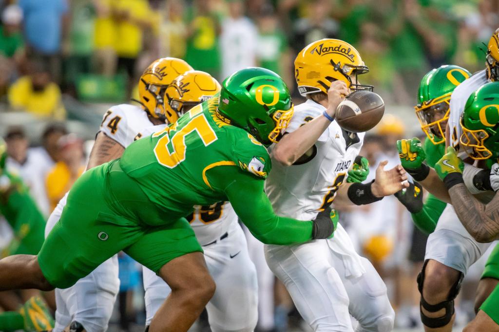 Derrick Harmon forces a fumble during Oregon's August 2024 game.