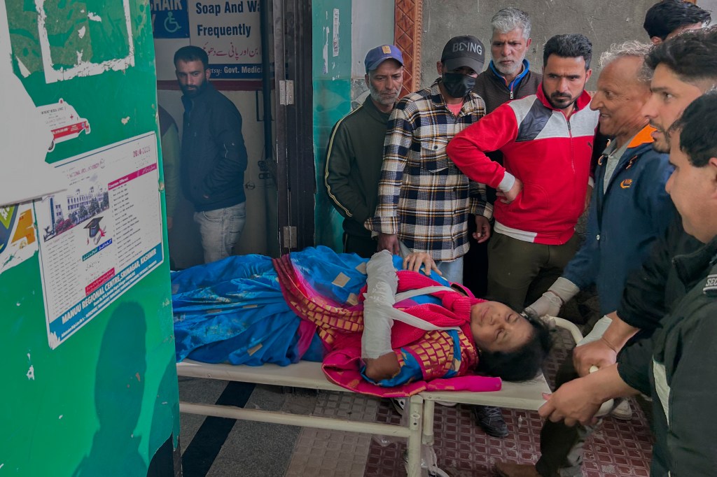 Paramedics carrying a wounded tourist on a stretcher in a hospital in Anantnag, after an attack in Indian controlled Kashmir.