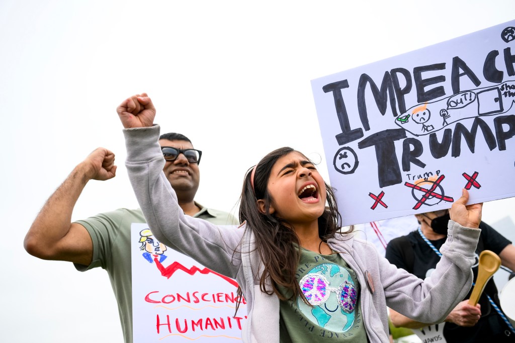 People gather on the National Mall to protest policies of the Trump administration, as well as Elon Musk's influence, in one of over a thousand rallies scheduled nationwide under the slogan Hands Off!, on April 5, 2025 in Washington, DC, little girl holding an impeach Trump sign
