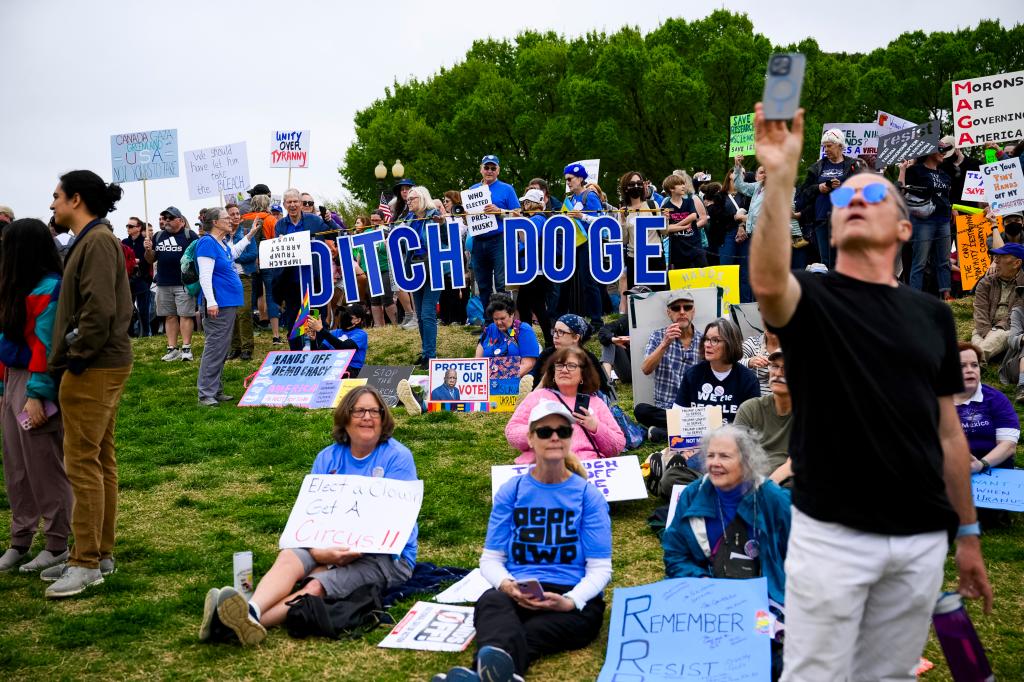 "Ditch DOGE" letters held up outside at the rally against Trump administration, as well as Elon Musk's influence