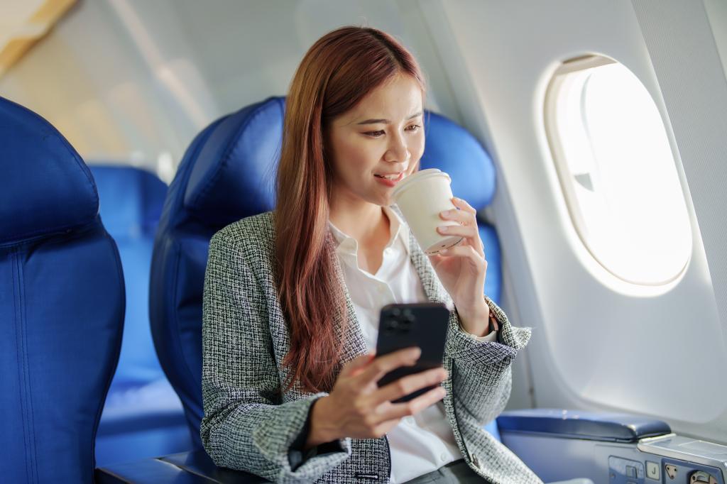 A woman drinking coffee on a plane. 