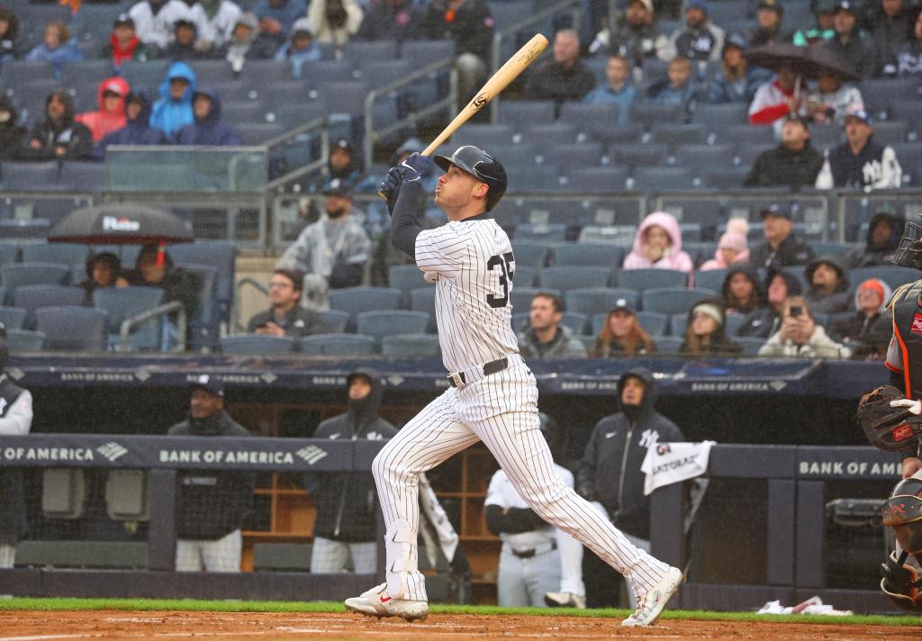 New York Yankees outfielder Cody Bellinger hitting an RBI triple during a game against the San Francisco Giants at Yankee Stadium
