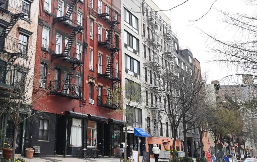A building with fire escape stairs on East 12th St., in the East Village of New York, depicting the plummeting demand and rental prices in the city.