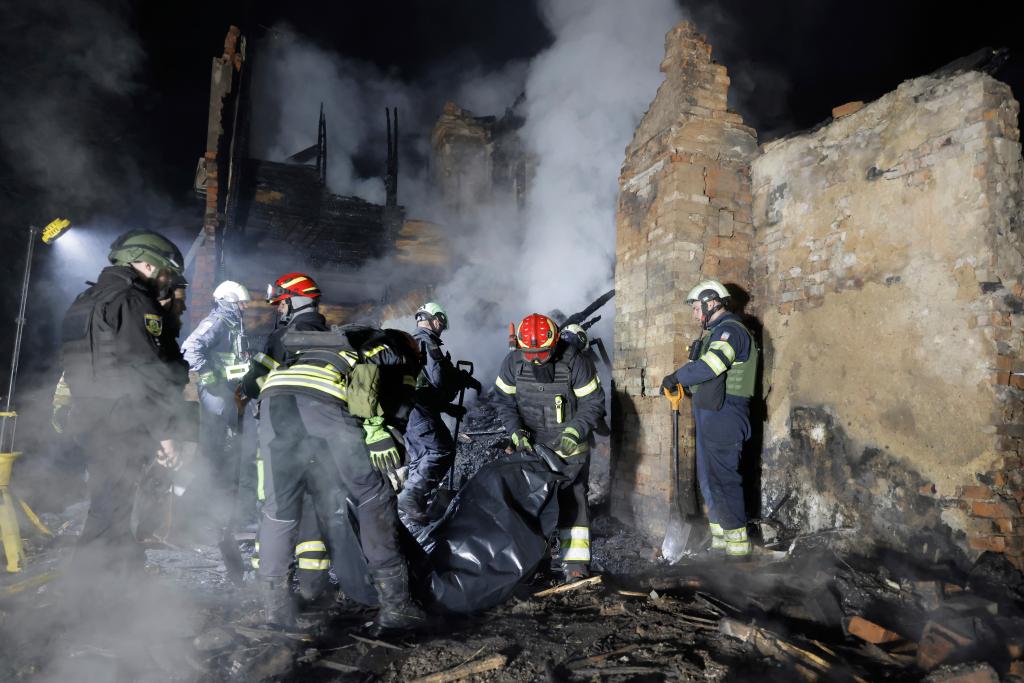Rescuers carry the body of a killed resident following Russia's drone attack in Kharkiv, Ukraine, late Thursday, April 3, 2025