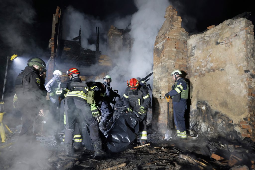 Rescuers carry the body of a killed resident following Russia's drone attack in Kharkiv, Ukraine, late Thursday, April 3, 2025