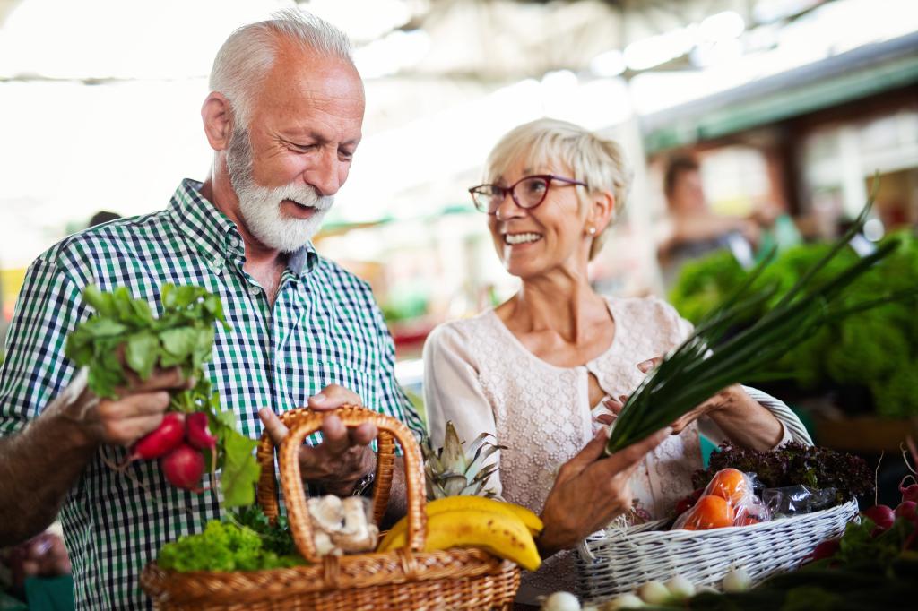 An elderly couple shops for produce. 