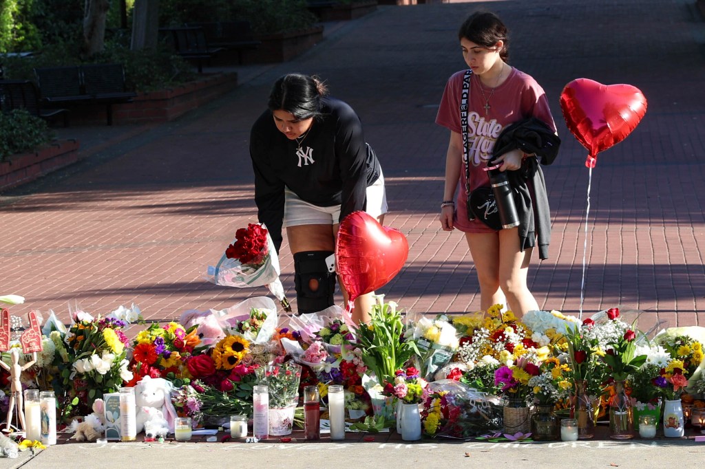 Students place flowers on a stretch of sidewalk near the center of the Florida State campus in sight of the Student Union building, Tallahassee, Fla., Friday, April 18, 2025. 