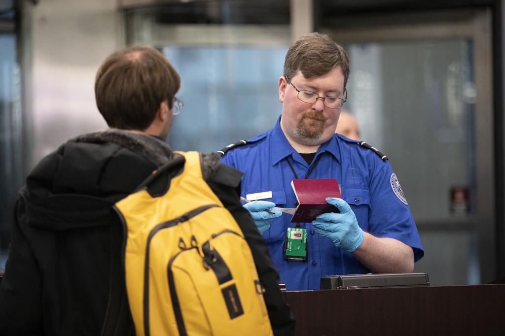 A Transportation Security Administration agent checks a flyer through security at O'Hare International Airport in 2019