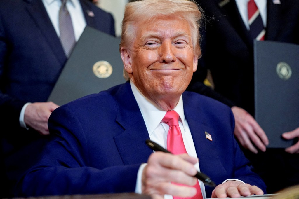U.S. President Donald Trump smiling while signing energy-related executive orders in the White House, Washington, D.C.