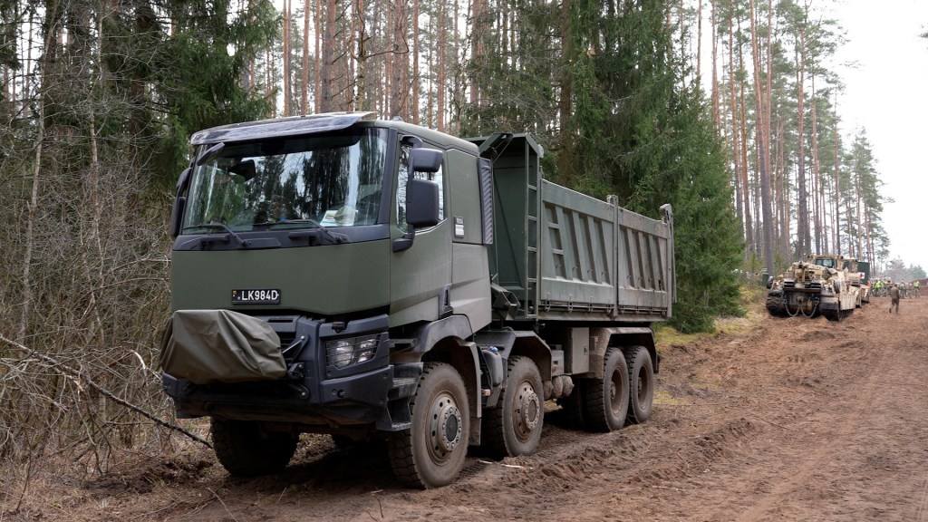 Rescue operation in progress at Pabrade training ground in Lithuania, featuring a large military vehicle on a dirt road, dated March 31, 2025.