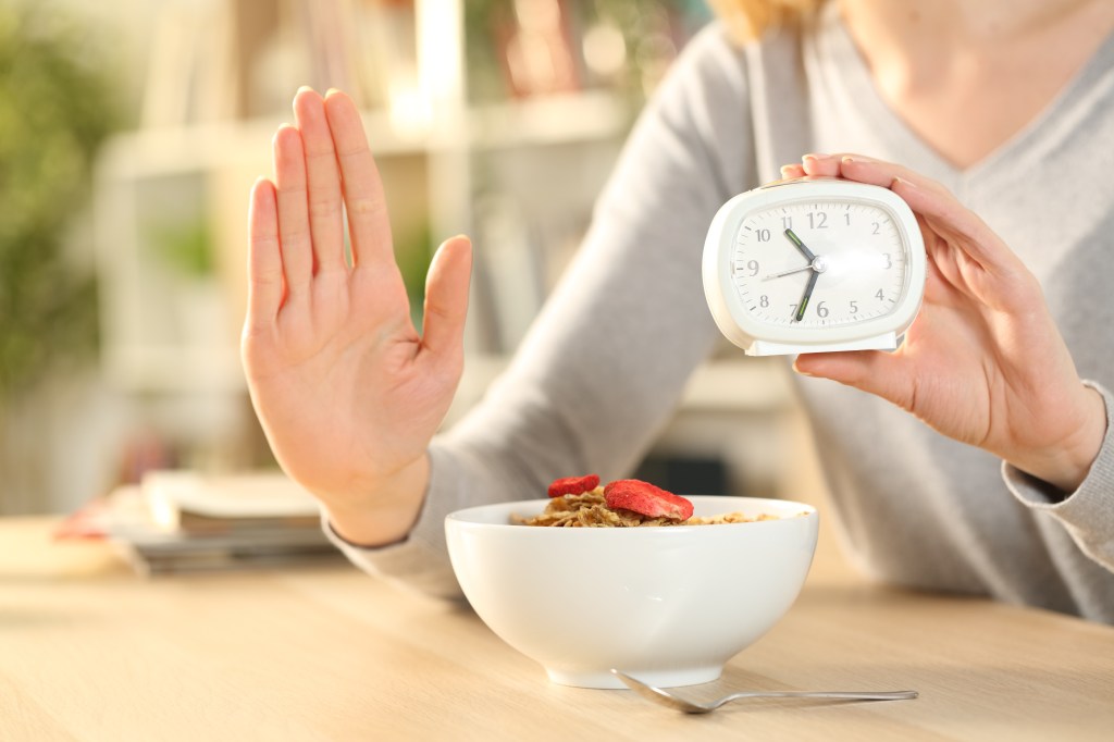 A women doing a stop sign while intermittent fasting. 