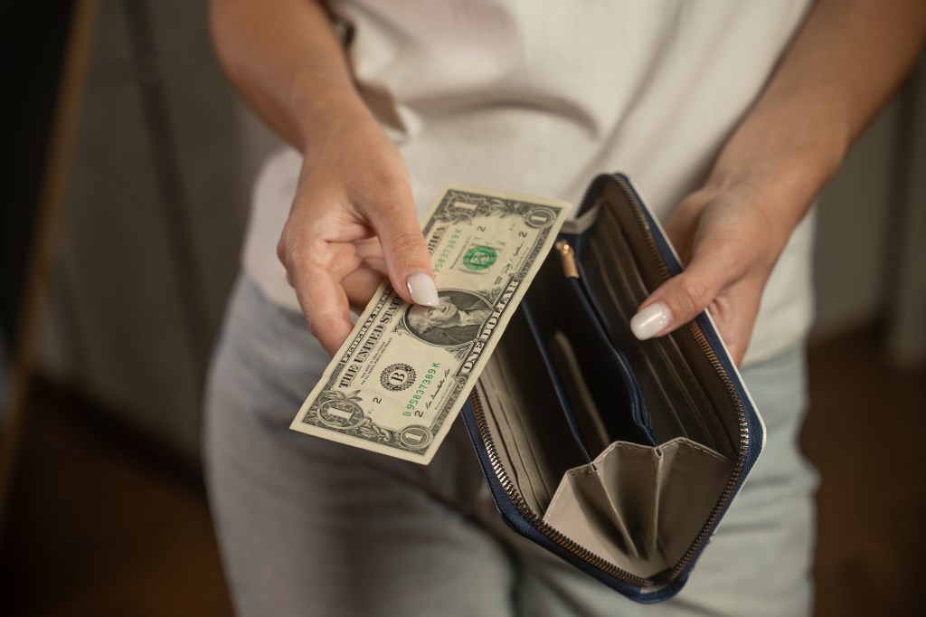 Woman opening an empty wallet. 