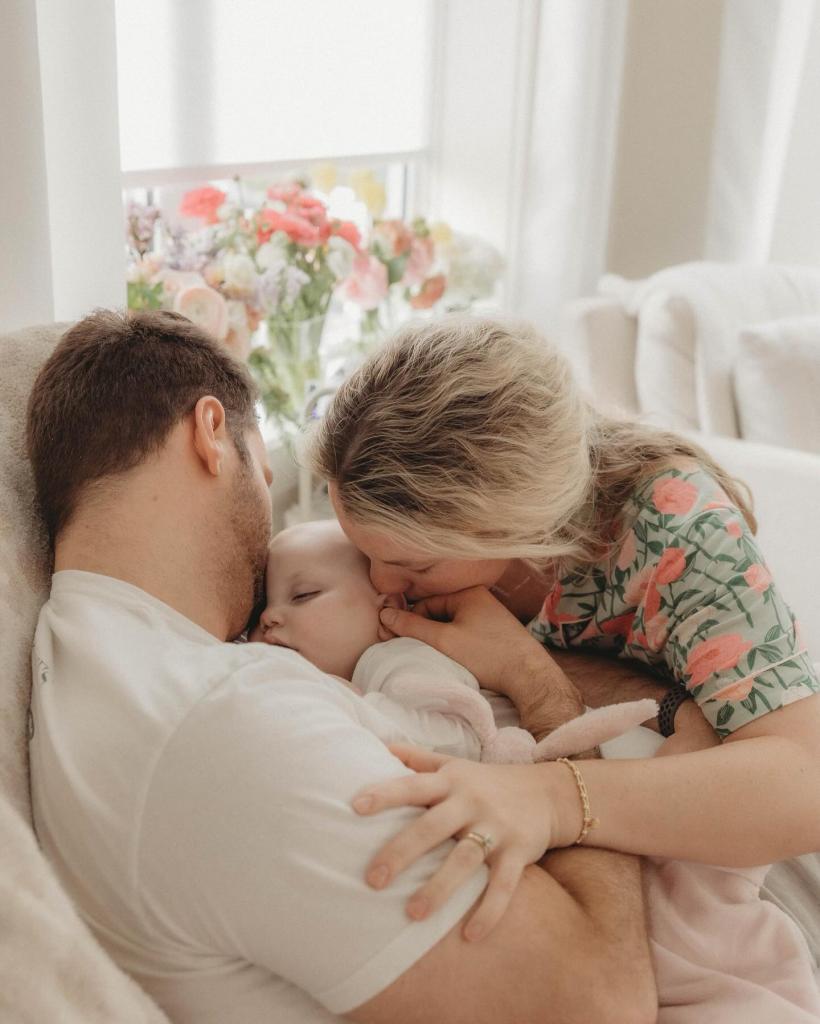 A man and woman holding their infant daughter, Lily Ann