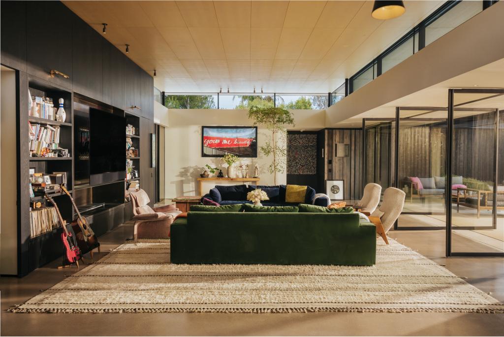 The living room is flooded with natural light by skylights and pivoting glass doors.