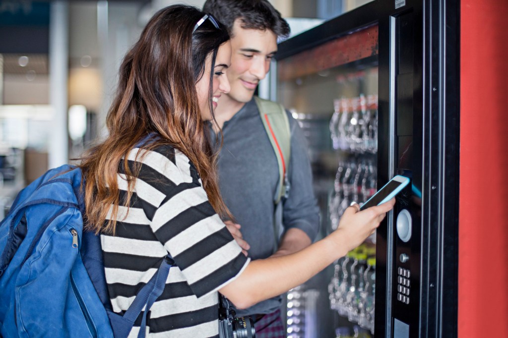 Bottled may be better than fountain drinks in terms of food safety. Here, a young couple pays for bottled drinks at an airport vending machine.