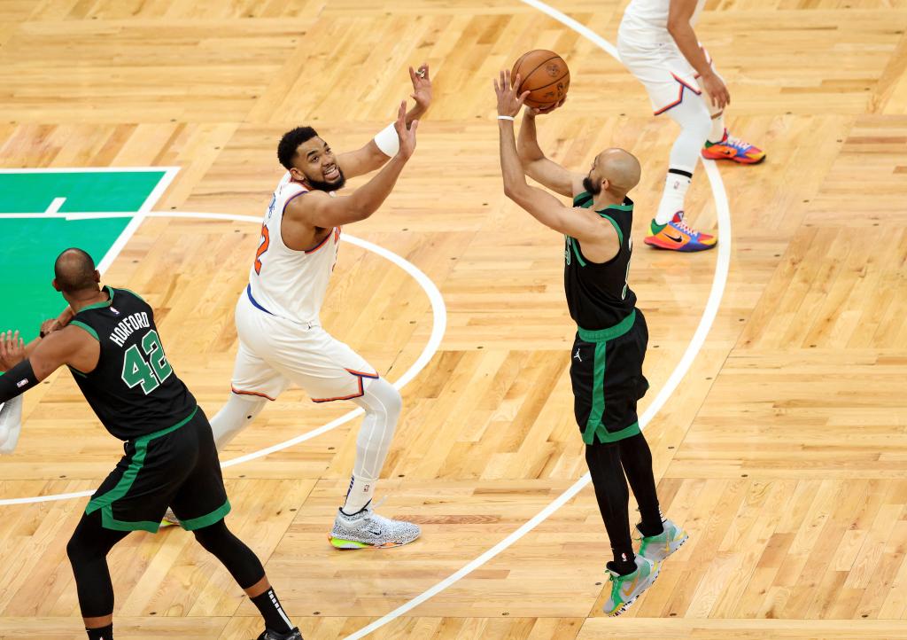 Derrick White #9 of the Boston Celtics puts up a 3-point shot over Karl-Anthony Towns 