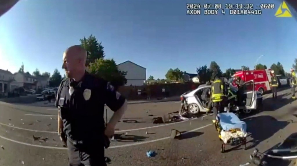 Police investigate the crash site as firefighters work to get Weaver out of the car after the crash in July 8, 2024.