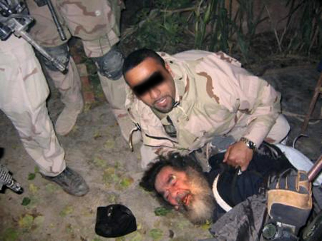 A soldier captures former Iraqi leader Saddam Hussein.