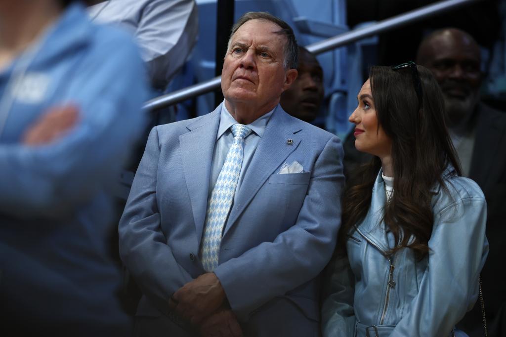 North Carolina Tar Heels football head coach Bill Belichick and his girlfriend Jordon Hudson look on during the first half of the game between the North Carolina Tar Heels and the Duke Blue Devils at Dean E. Smith Center on March 08, 2025 in Chapel Hill, North Carolina. 