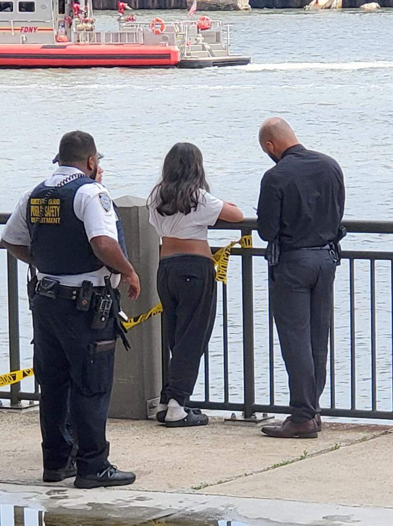 The missing teen's friend talks to police officers next to the river.