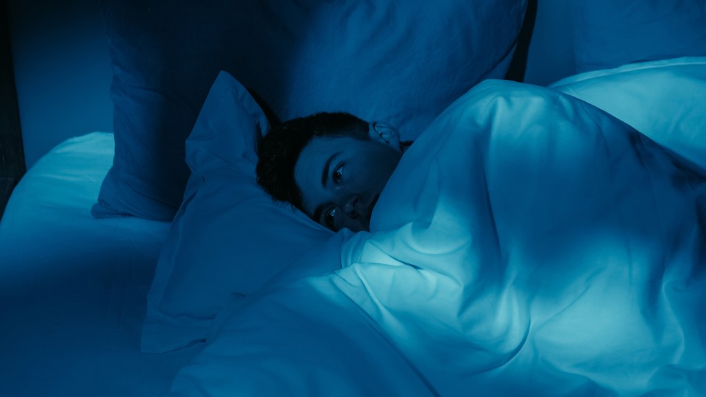 A new study finds that just three nights of sleep deprivation can increase the risk of heart disease — even in young and healthy adults. Here, a man struggles to sleep in his bed.