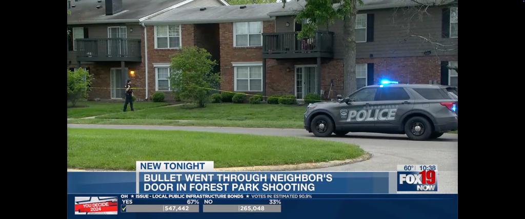 Police car and officer outside Cincinnati apartment complex.