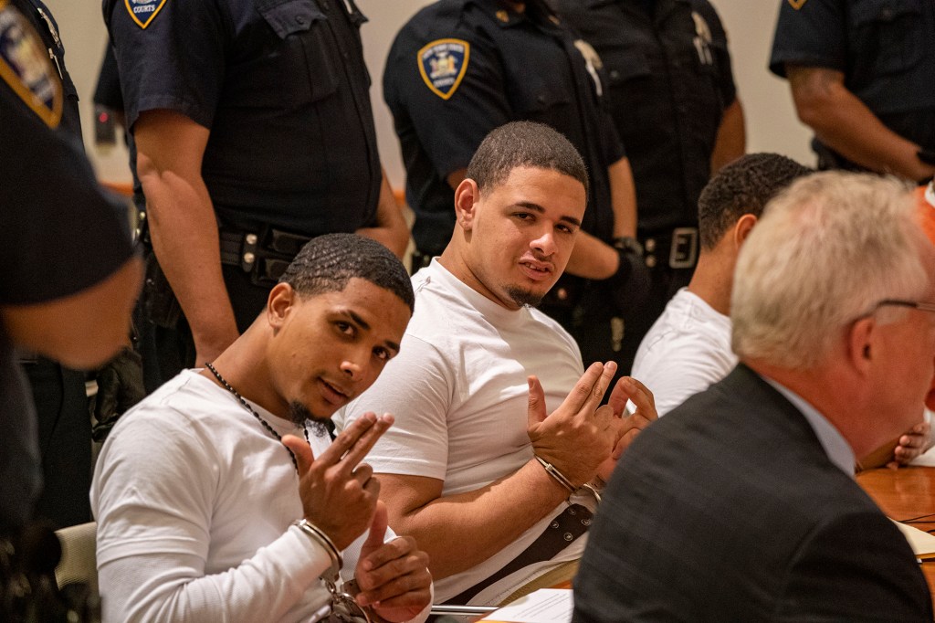 Killers flash signs in court.
