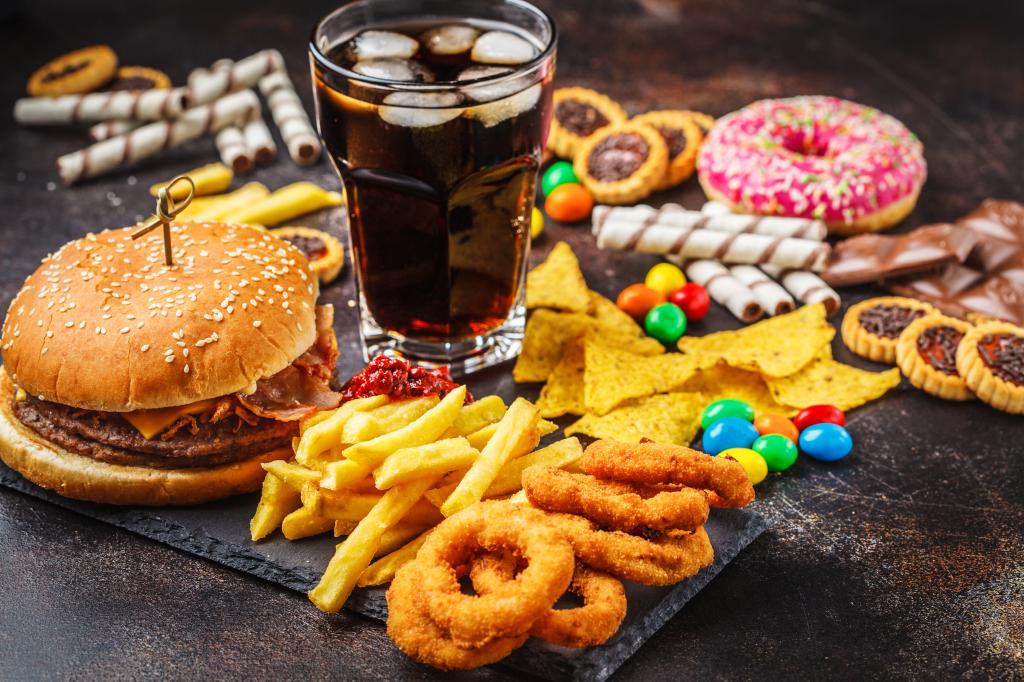 Ultra-processed foods include sauces, spreads, condiments, packaged sweets, snacks, desserts, artificially or sugar-sweetened beverages and animal-based products. An array of junk food is seen here.