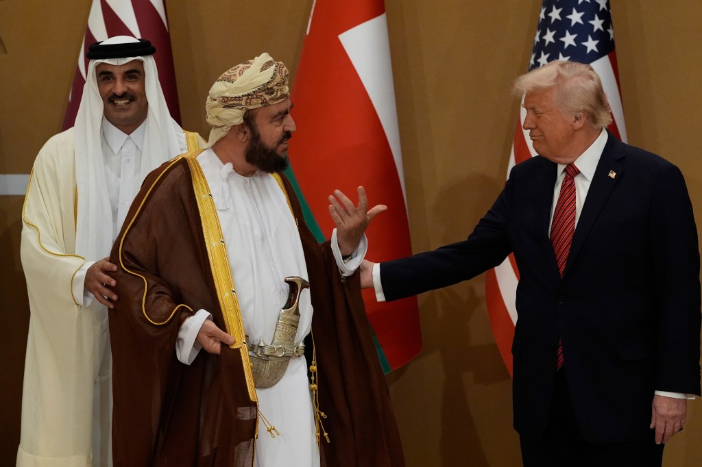 President Donald Trump speaks with Oman's Deputy Prime Minister for International Affairs Al Sayyid Asaad Tariq Taimur Al Said, center, and Qatar's Emir Sheikh Tamim bin Hamad Al Thani as they arrive to attend a group photo with Gulf Cooperation Council leaders during the GCC Summit.