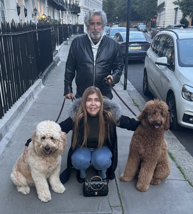 Lawyer Bob Amsterdam poses with client Sara Saleem and two shaggy dogs.
