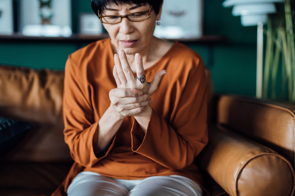 Weaker grip strength may be linked to diabetes and a higher risk of cognitive decline, dementia, heart failure and stroke. An easy tennis ball test can gauge grip strength. Here, a woman rubs her hand in discomfort.