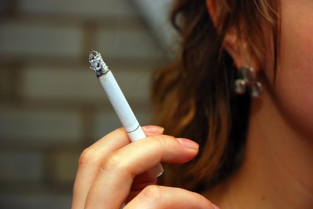 A woman smokes a cigarette. 
