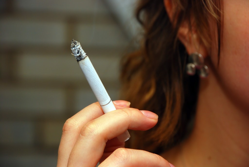 A woman smokes a cigarette. 