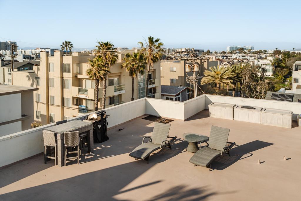 The condo includes access to a shared rooftop and guest parking, a rare perk for a beachfront LA property. 