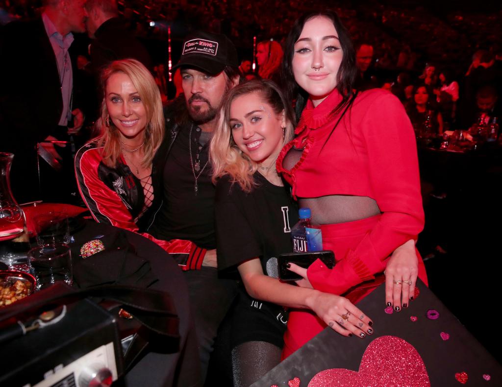 Tish Cyrus, and singers-songwriters Billy Ray Cyrus, Miley Cyrus, and Noah Cyrus pose with a sign reading 'I heart Noah Cyrus' during the 2017 iHeartRadio Music Awards.