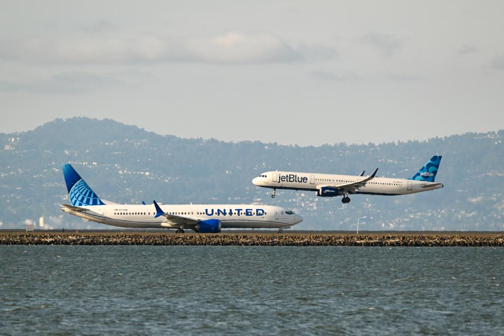 United Airlines plane taking off and JetBlue plane landing at San Francisco International Airport on June 8, 2023
