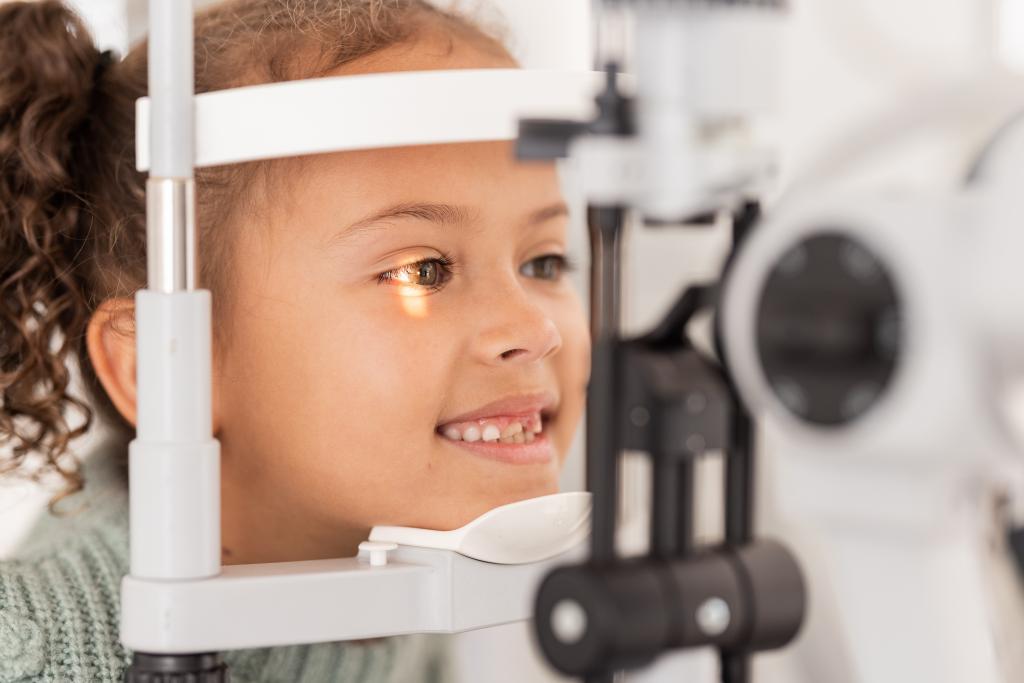 Girl undergoing eye exam in optometrist's office with eye care equipment