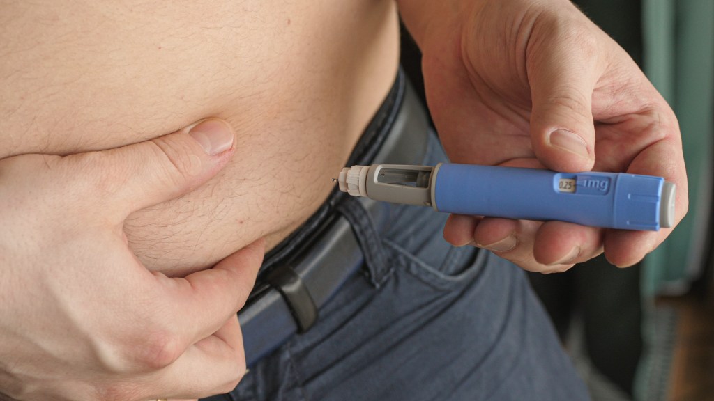 A person injecting semaglutide.