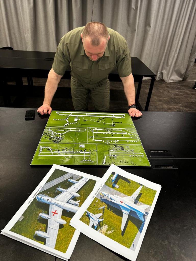 Man reviewing map and aerial photos of a Russian military airbase.