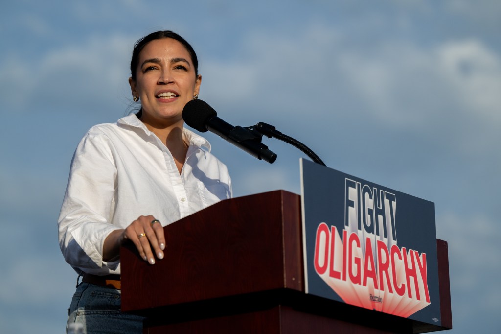 Alexandria Ocasio-Cortez speaking at a "Fight Oligarchy" rally.