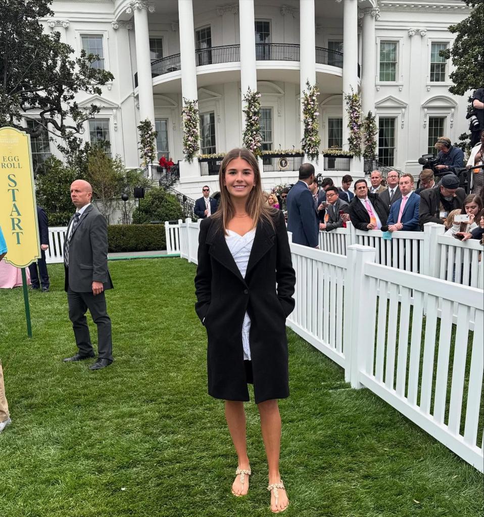 Woman standing on the lawn in front of the White House.