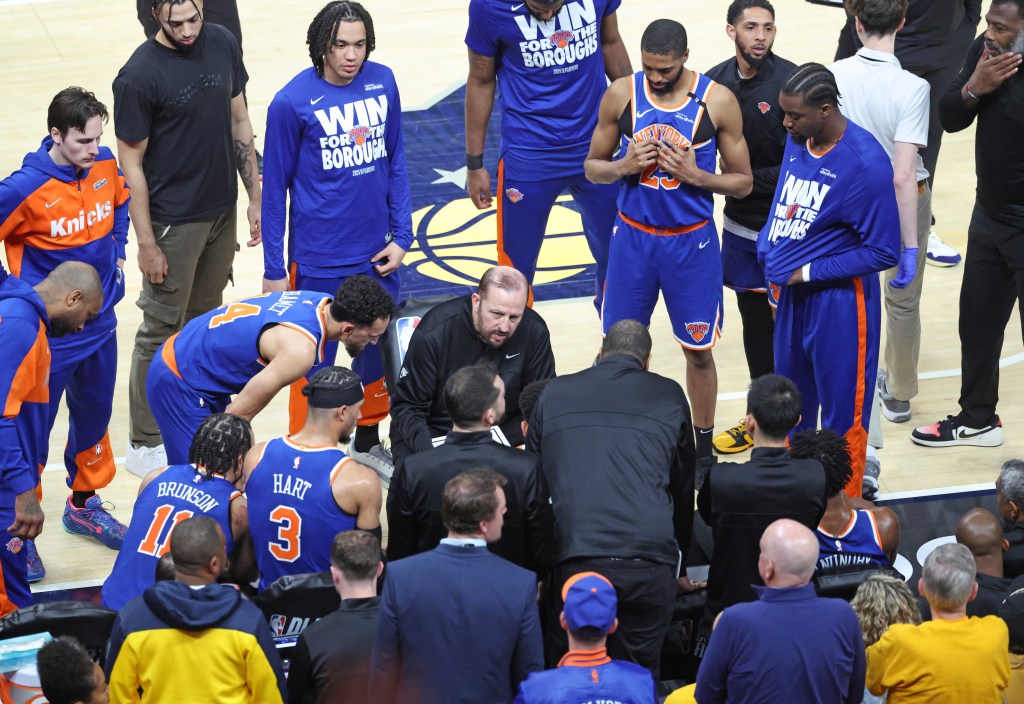 New York Knicks coach Tom Thibodeau speaks with his team on the bench.