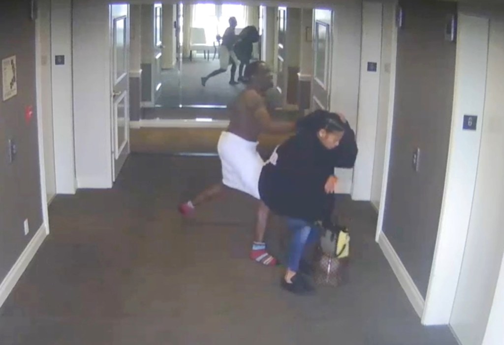 Surveillance footage of a man in a towel grabbing a woman in a hotel hallway.