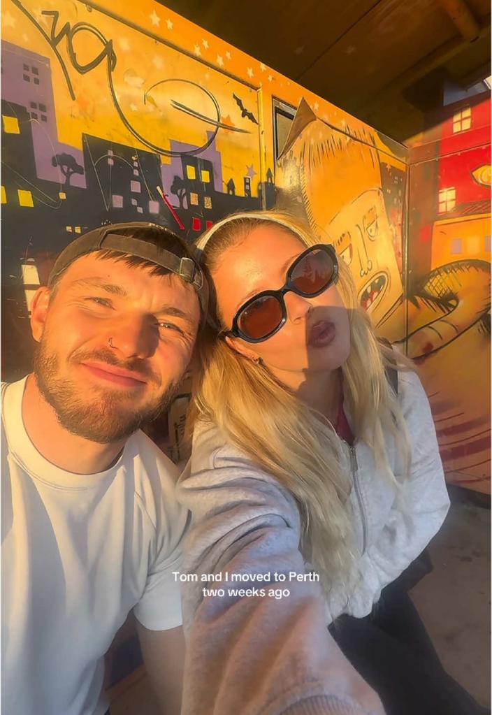 A young couple smiling while discussing their viral TikTok hack to live rent-free by pet sitting during their travels across Australia.